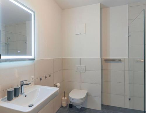 La salle de bains blanche est pourvue de toilettes et d'un lavabo. dans l'établissement Appartement Almblick, à Brixen im Thale