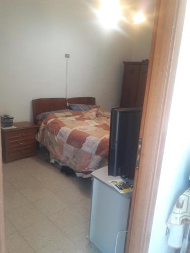 - une chambre avec un lit et un bureau avec une télévision dans l'établissement Casa Vacanze Clementina, à Paduli
