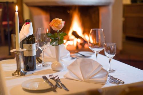 a table with a candle and wine bottles and glasses at Aparthotel Andreas Hofer in Kufstein