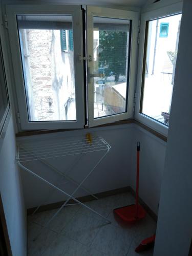 a room with three windows and a red object in it at Isi GuestHouse in Iesi