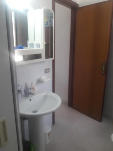 La salle de bains est pourvue d'un lavabo blanc et d'un miroir. dans l'établissement Casa Vacanze Clementina, à Paduli