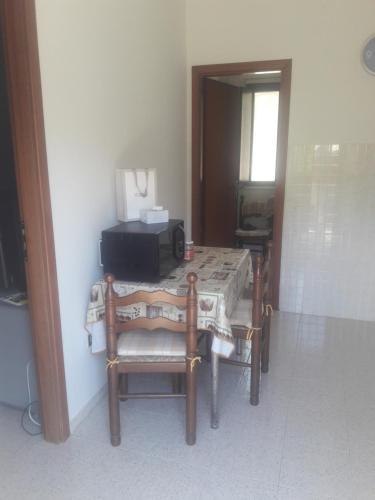 a table and chairs with a microwave on top of it at Casa Vacanze Messano in Paduli