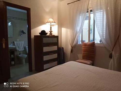 a bedroom with a bed and a bathroom with a sink at Calle José Payán nº 28, 1º B in Camas