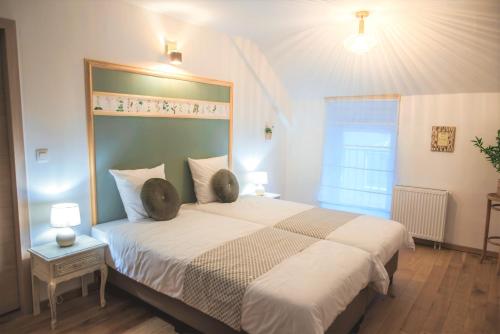 a bedroom with a large bed with a large headboard at Le pavillon de l'herboriste 14p jacuzzi jardin in Tintigny