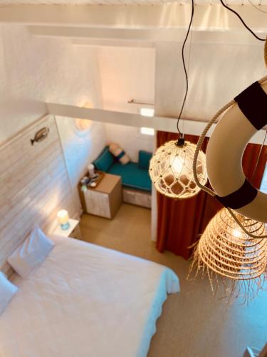 a bedroom with a bed and a hanging lamp at Hôtel Île de Lumière in La Cotinière