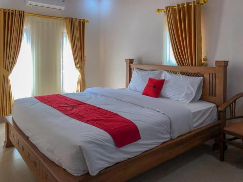1 dormitorio con cama grande y almohada roja en RedDoorz near XT Square 3, en Yogyakarta