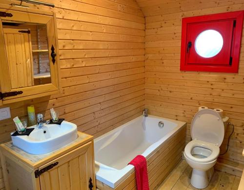 a bathroom with a tub and a toilet and a sink at Guest House du Grand Paradis - On Piste in Champéry