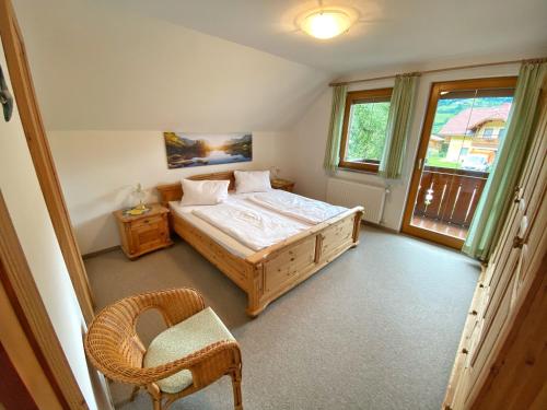 1 dormitorio con 1 cama, 1 silla y 1 ventana en Ferienhaus Schaller am Galsterberg, en Pruggern