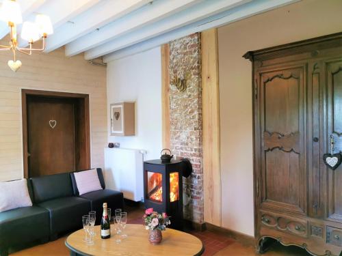 a living room with a couch and a fireplace at Le pavillon de l'herboriste 14p jacuzzi jardin in Tintigny