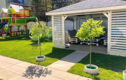 a backyard with two trees and a gazebo at Tu Urlop in Mielno