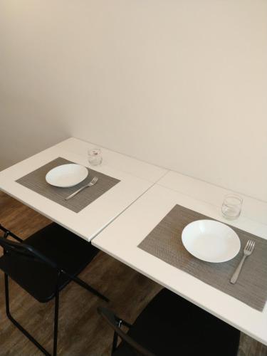 a white table with two white plates on it at Isi GuestHouse in Iesi