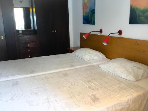 a bedroom with a large bed with two pillows at Apartamentos Sirena in Mogán