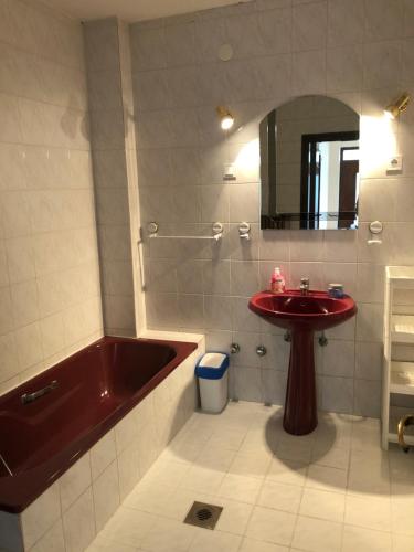 a bathroom with a tub and a sink and a mirror at Tekergő Vendégház in Balatonfüred
