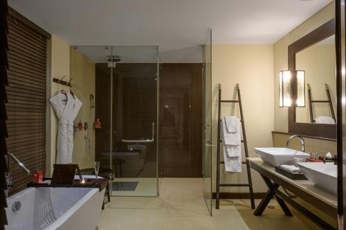 y baño con ducha acristalada y lavamanos. en Water Garden Sigiriya, en Sigiriya