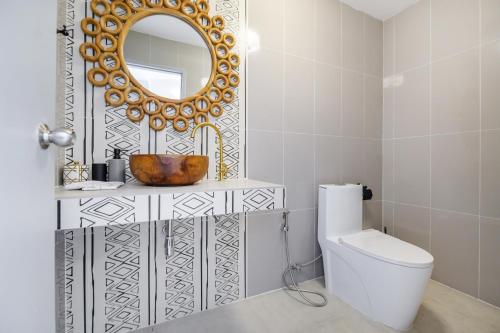 a bathroom with a sink and a mirror and a toilet at The Mellow at Thong Lo in Bangkok