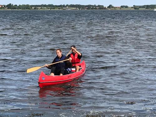 two people in a red canoe on a lake at Villa Wiegand - a room with a view in Holbæk