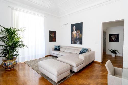 un soggiorno bianco con divano e tavolo di Casa Vacanze Il Duomo a Catania