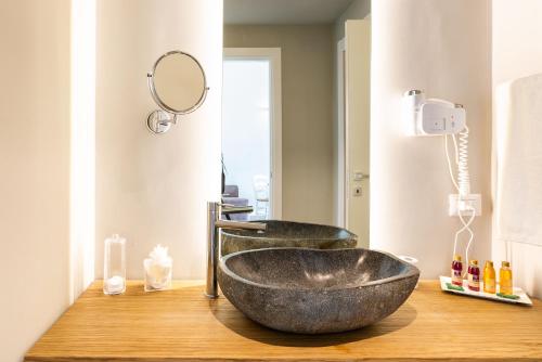a bathroom with a bowl sink and a mirror at Kepos Etna Relais & Exclusive Spa in Santa Venerina