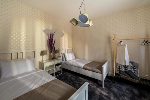 Una habitación de hotel con dos camas y una lámpara. en Villa Louis, en Ventspils