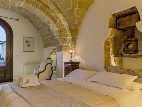 a bedroom with a large bed with a stone wall at TENUTAYALA - Residenza Agrituristica in Parabita