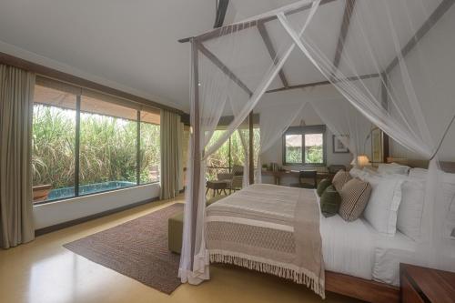 1 dormitorio con 1 cama blanca con dosel en Water Garden Sigiriya, en Sigiriya