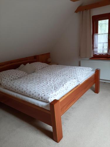 a bedroom with a wooden bed in a room at Chata Konzajf in Hrabušice