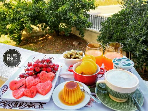 einen Tisch mit Obstteller und Getränken in der Unterkunft B&b Tre Perle in Gallipoli