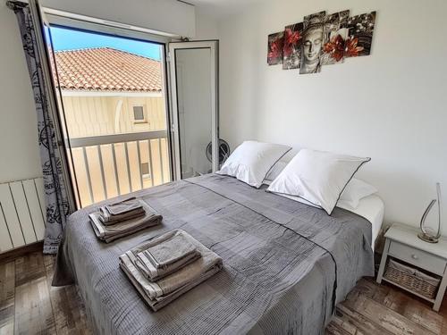 um quarto com uma cama grande e toalhas em APPART JL Port Fréjus em Fréjus