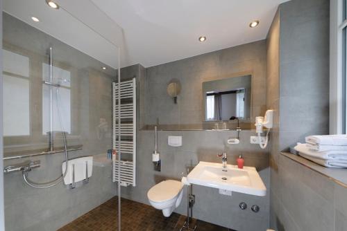 a bathroom with a sink, toilet and bathtub at Hotel Alte Post in Oberammergau