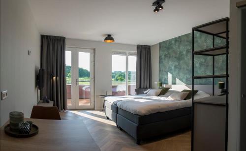 a bedroom with a large bed and a large window at Heuvelrijk Berg en Dal in Groesbeek