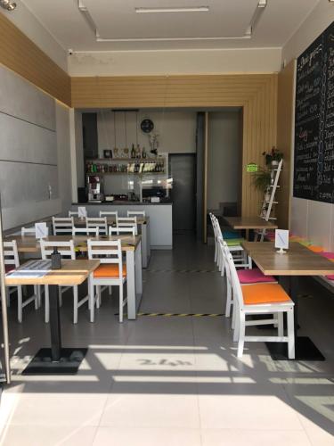 ein Restaurant mit Tischen und Stühlen und einer Küche in der Unterkunft Hotel City in Gniezno