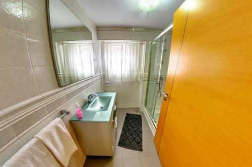 un bagno con lavandino e specchio di Apartamentos 7 Saias - Centro a Nazaré