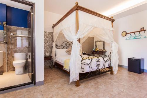 1 dormitorio con cama con dosel y baño en Hometown B&B en Hualien