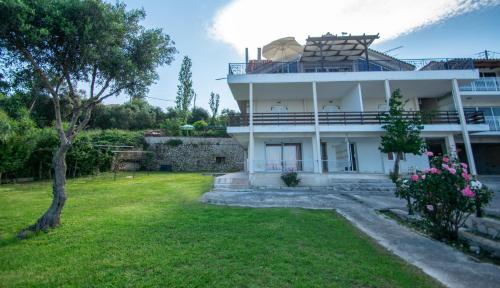 a large white house with a yard in front of it at Paradiso Del Mare On the Beach in Zakynthos Town