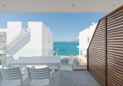 a balcony with a table and chairs and the ocean at COSTA VASIA Seaside Suites and Apartments in Vrahati