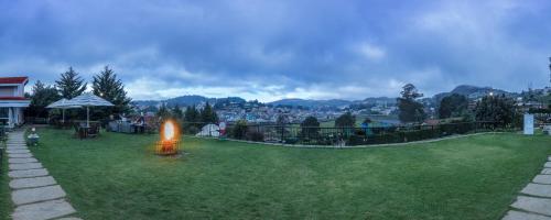 a yard with a fire in the grass at Club Mahindra Derby Green, Ooty in Ooty