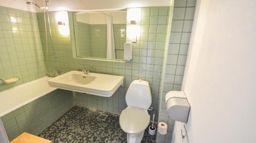 a bathroom with a sink and a toilet and a mirror at Hotel Østersø in Aabenraa