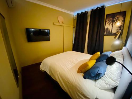Dormitorio con cama con almohada amarilla en I Cannes Sleep - Centre ville au calme, en Cannes