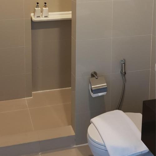 a bathroom with a toilet and a shower at KOS Hotel Suvarnabhumi Airport -SHA Extra Plus in Min Buri