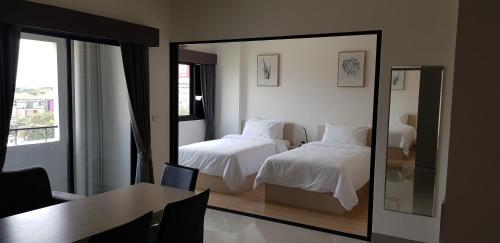 a hotel room with two beds and a mirror at KOS Hotel Suvarnabhumi Airport -SHA Extra Plus in Min Buri