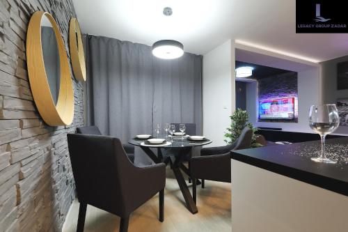 a dining room with a table with chairs and wine glasses at Legacy Marine2 - Zadar, Luxury Suites in Zadar