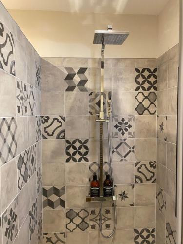 eine Dusche im Bad mit einer gefliesten Wand in der Unterkunft La Suite du 12 in Brie