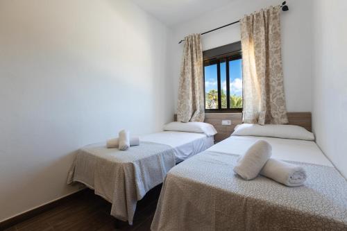 dwa łóżka w pokoju z oknem w obiekcie APARTAMENTO BOLONIA SUR A w mieście Bolonia
