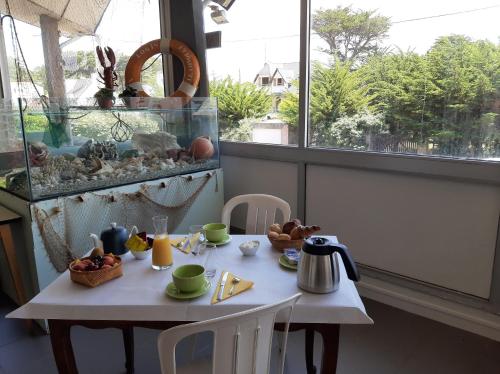 une table avec de la nourriture à côté d'une fenêtre dans l'établissement Home des Pins SARL, à Saint-Pierre-Quiberon