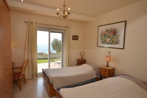 a bedroom with two beds and a window with a view at Villa piscine Eze bord de mer à 500m de la plage in Èze
