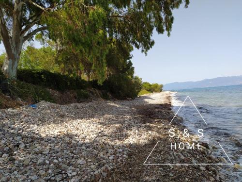 a rocky beach with a sign that says sterk home at S&S Home in Petalidhion