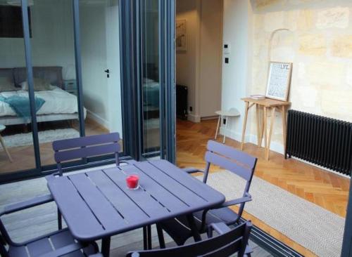 a purple table and chairs in a room with a bed at Burdigala Homes - Appart rue Minvielle in Bordeaux