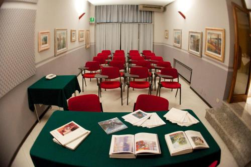 a room with a long table and red chairs at Hotel Milano in Pistoia