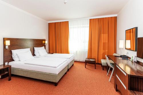 パルドゥビツェにあるホテル ユーロのベッドとデスクが備わるホテルルームです。