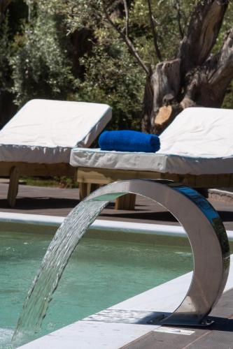 a water fountain in front of a pool with beds at ANATOLI VILLAS in Nikiana